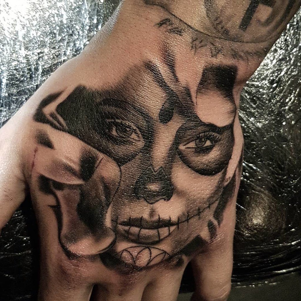Rostro de catrina hiperrealista tatuado sobre el dorso de una mano